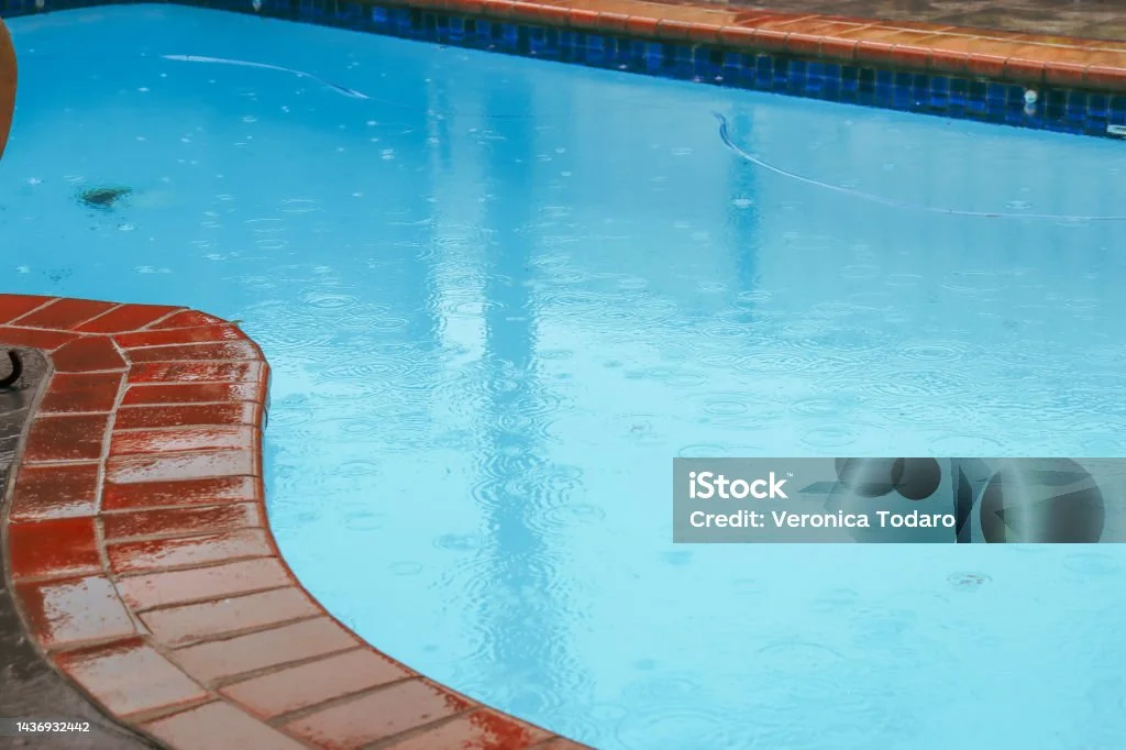 Rain falling on a backyard pool